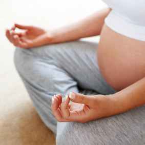 Schwangere Frau in Meditationshaltung